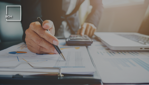 Consulente analizza documenti e dati per la pianificazione fiscale strategica aziendale.